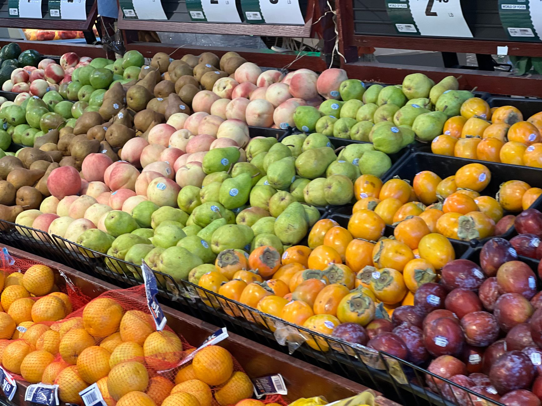 Colorful assortment of fresh fruits on display at a bustling market stand.