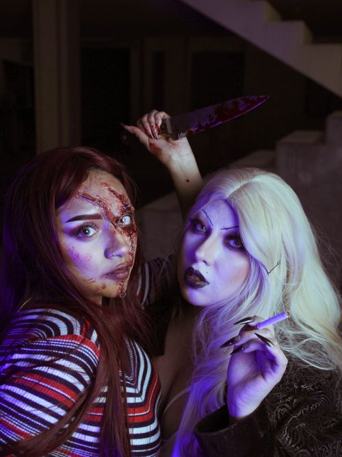 Free Two women with gothic Halloween makeup and a bloody knife in an eerie setting. Stock Photo