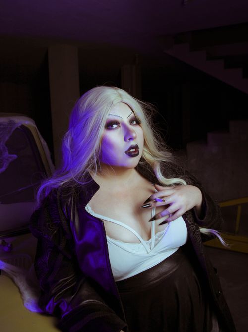 Free Gothic style portrait of a woman with dramatic makeup in a dimly lit setting. Stock Photo