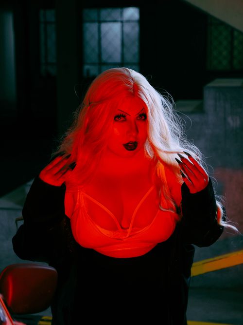 Free A captivating portrait of a woman with intense red lighting creating a dramatic effect. Stock Photo