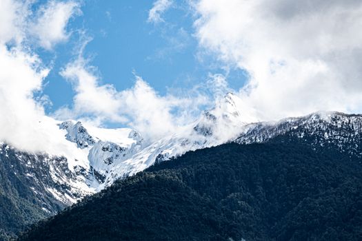 Breathtaking view of snow-capped mountains under a vibrant blue sky in the Andes, Chilean Patagonia.