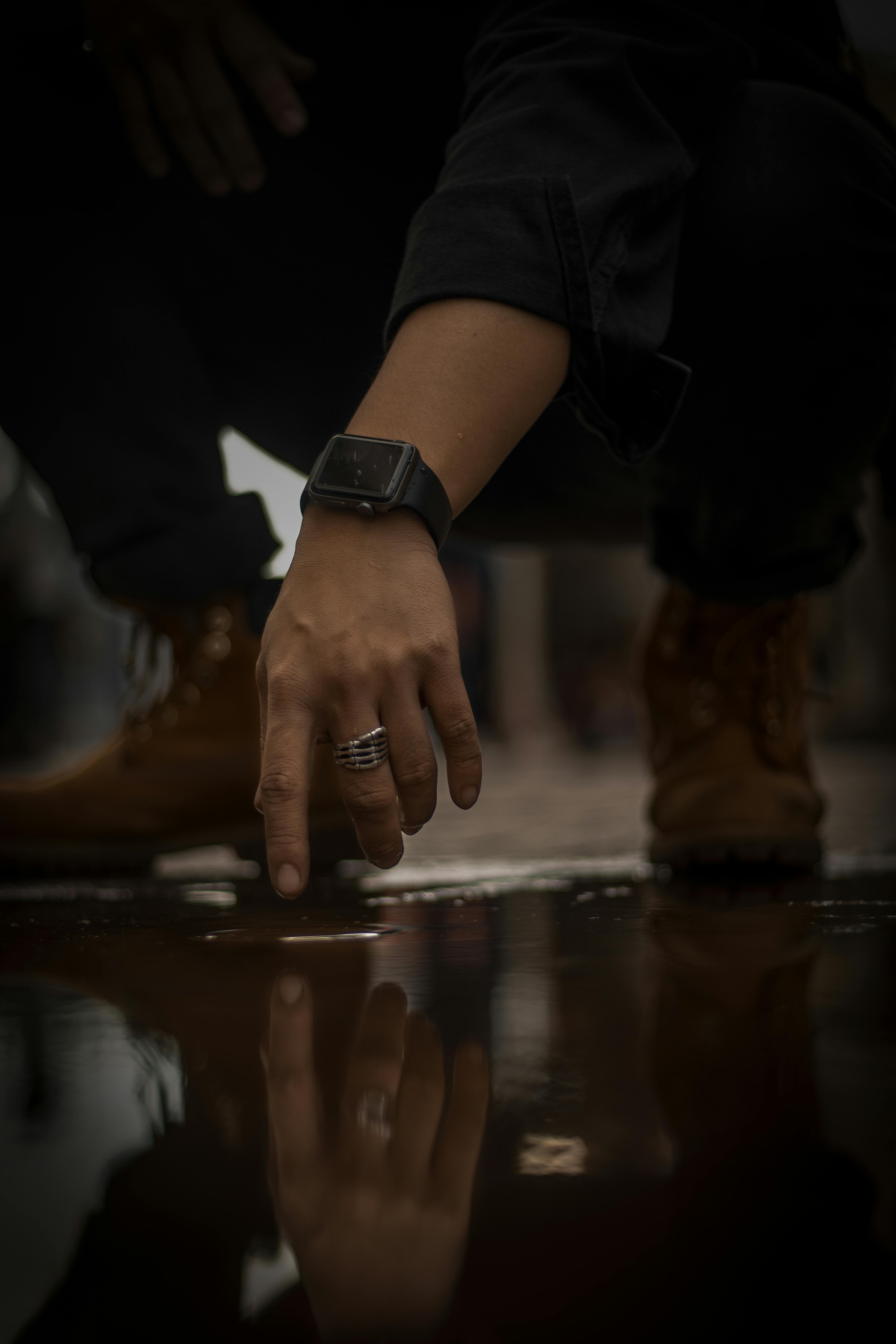 man sits down to touch water residue in the ground