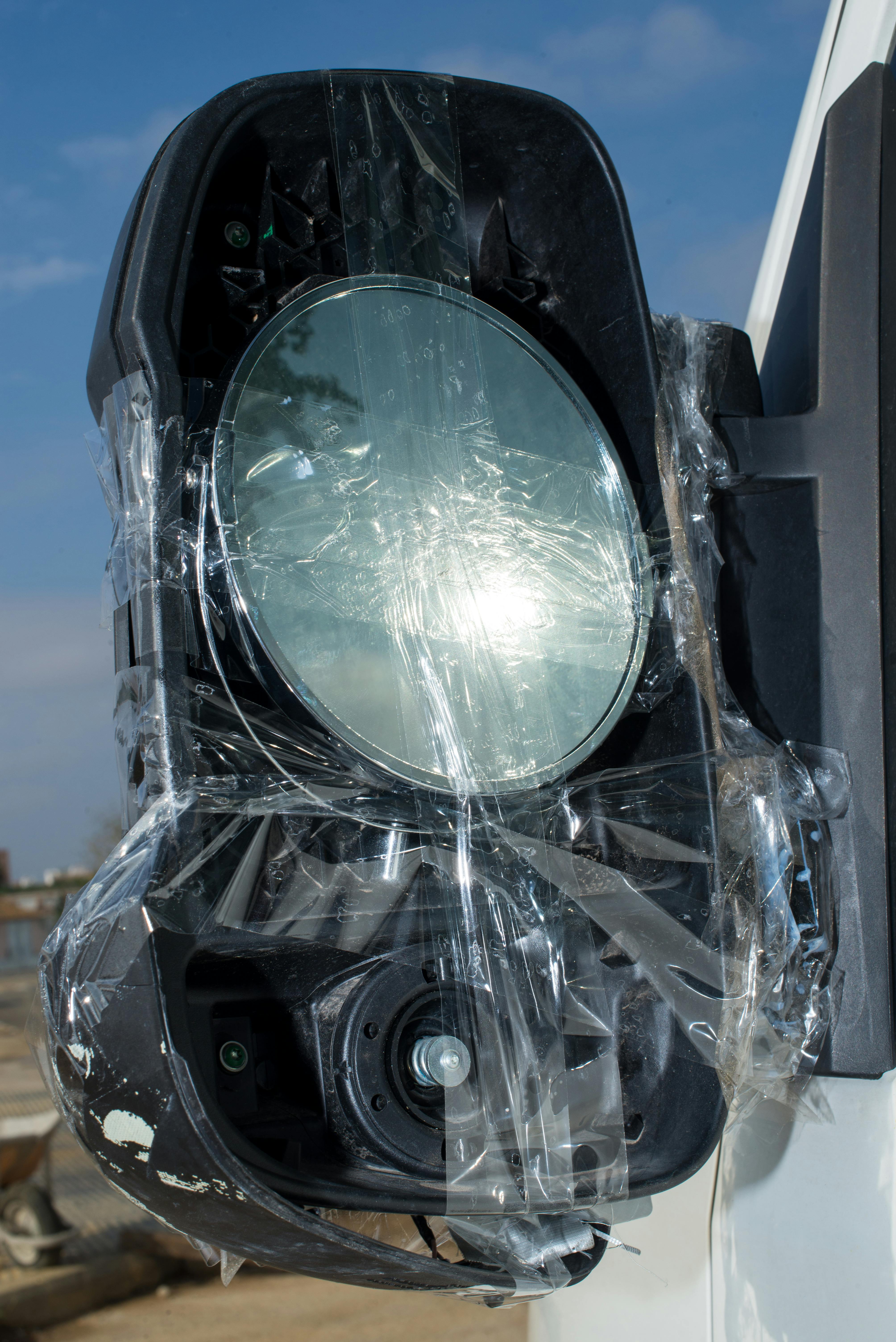 vehicle side mirror repair with tape outdoors