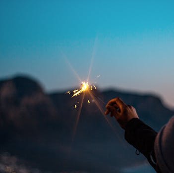 在南非开普敦的黄昏天空下，一只手拿着烟花