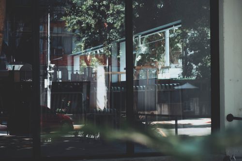 Free Reflection of urban street scene on modern glass building facade. Stock Photo