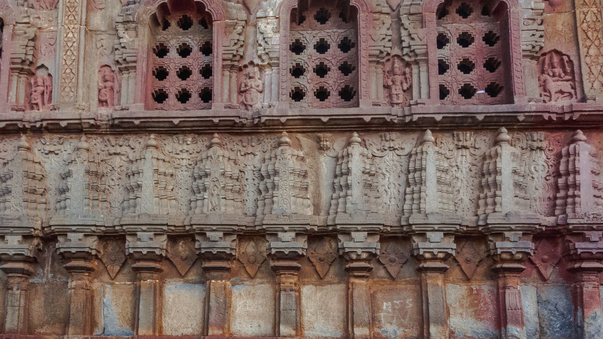 Close-up of detailed stone carvings on an ancient temple wall showcasing architectural artistry.