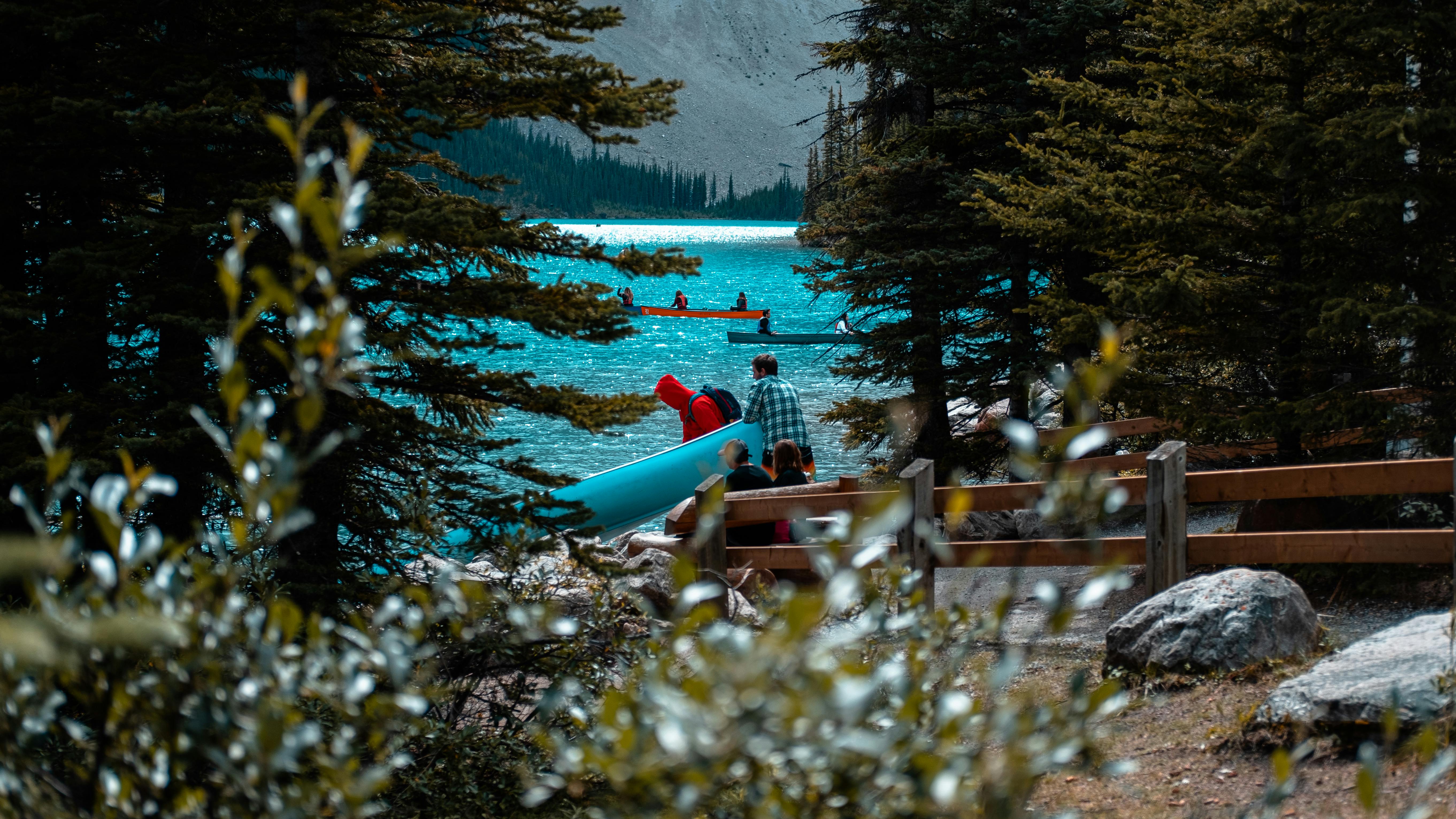 绿树成荫的路易斯湖上，人们划着独木舟，一片宁静