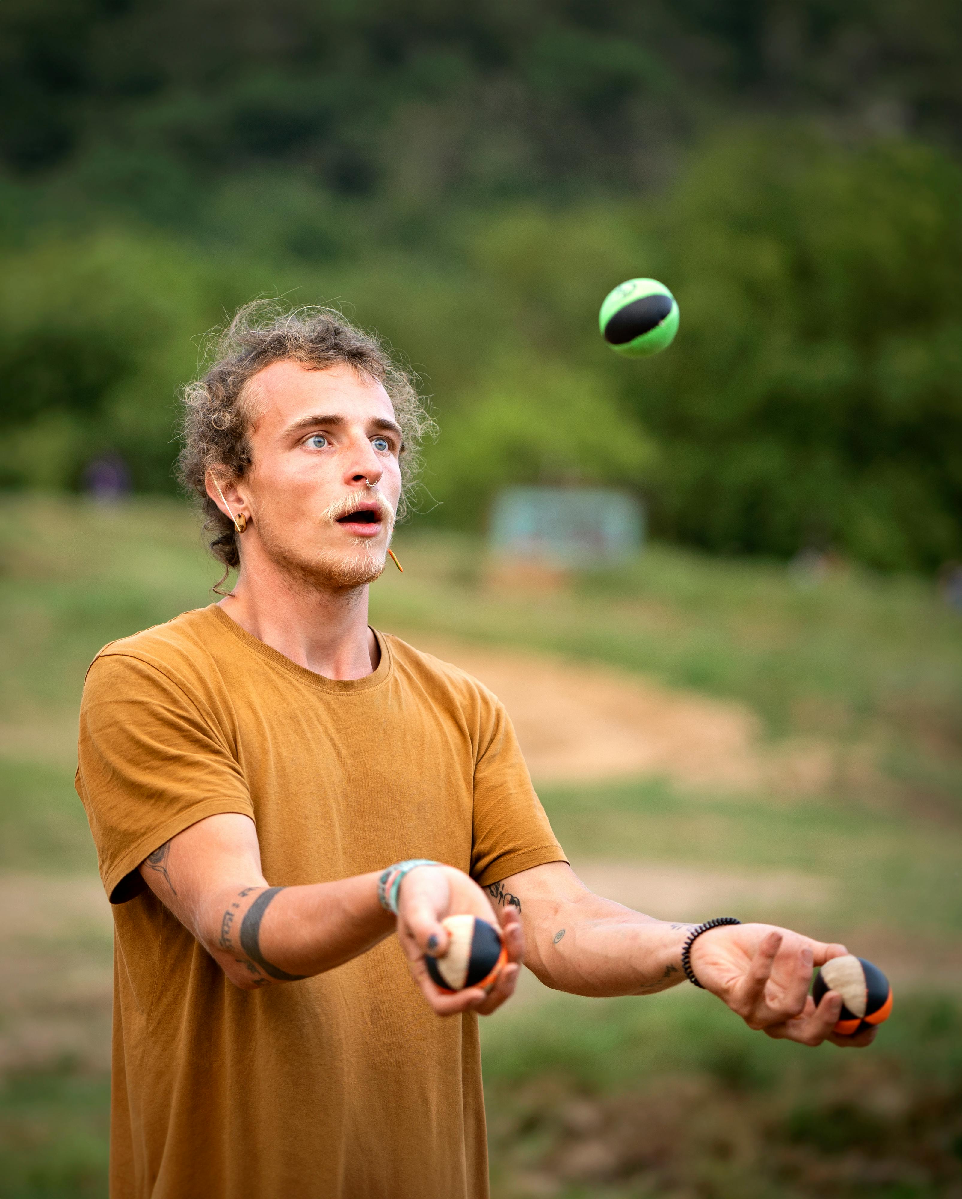 man juggling outdoors in sunny day