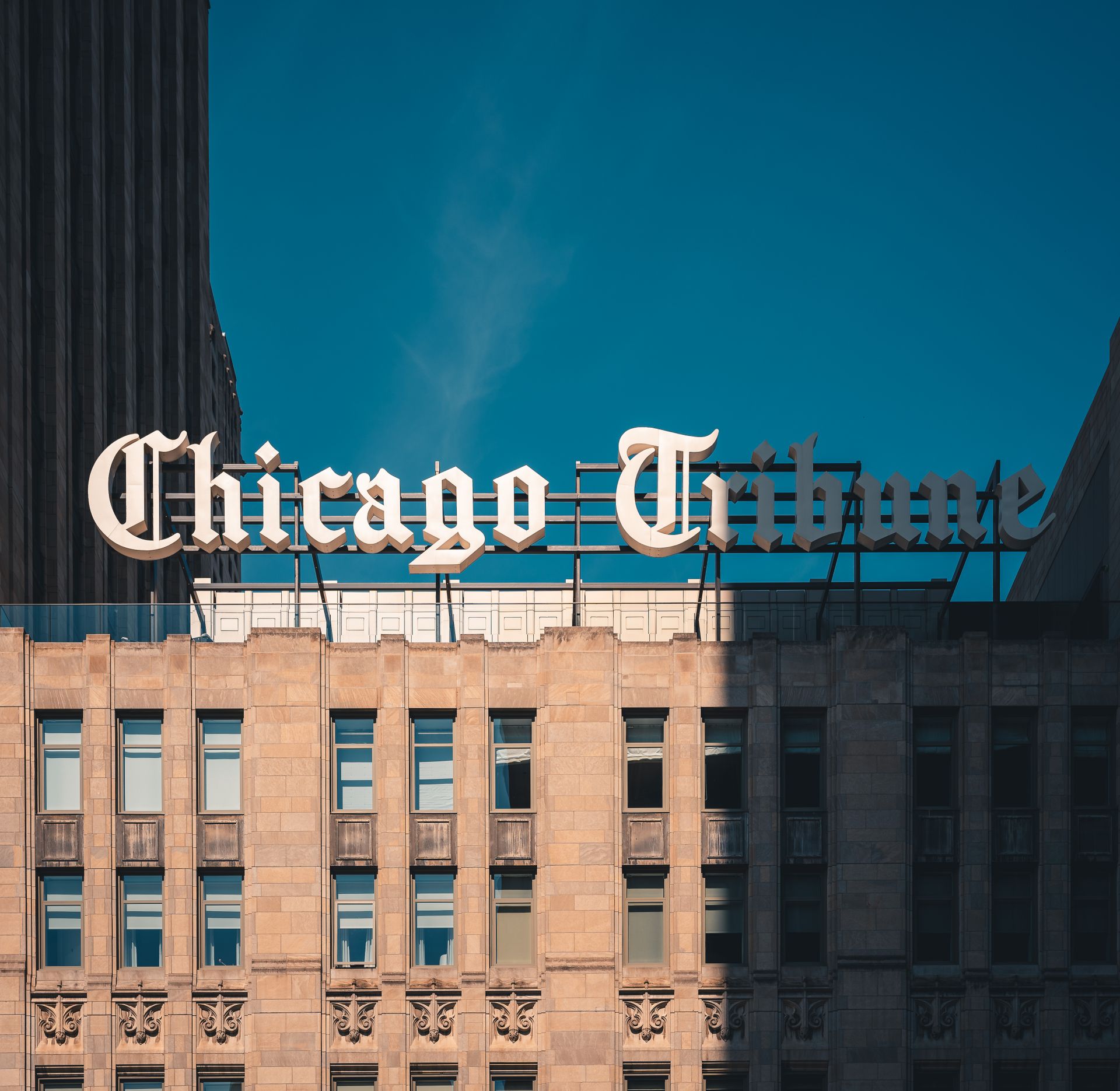 Close-up of Chicago Tribune Building architecture under a clear blue sky.