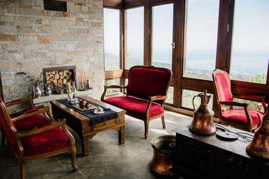 Cozy vintage living room with elegant red furniture and a sea view.