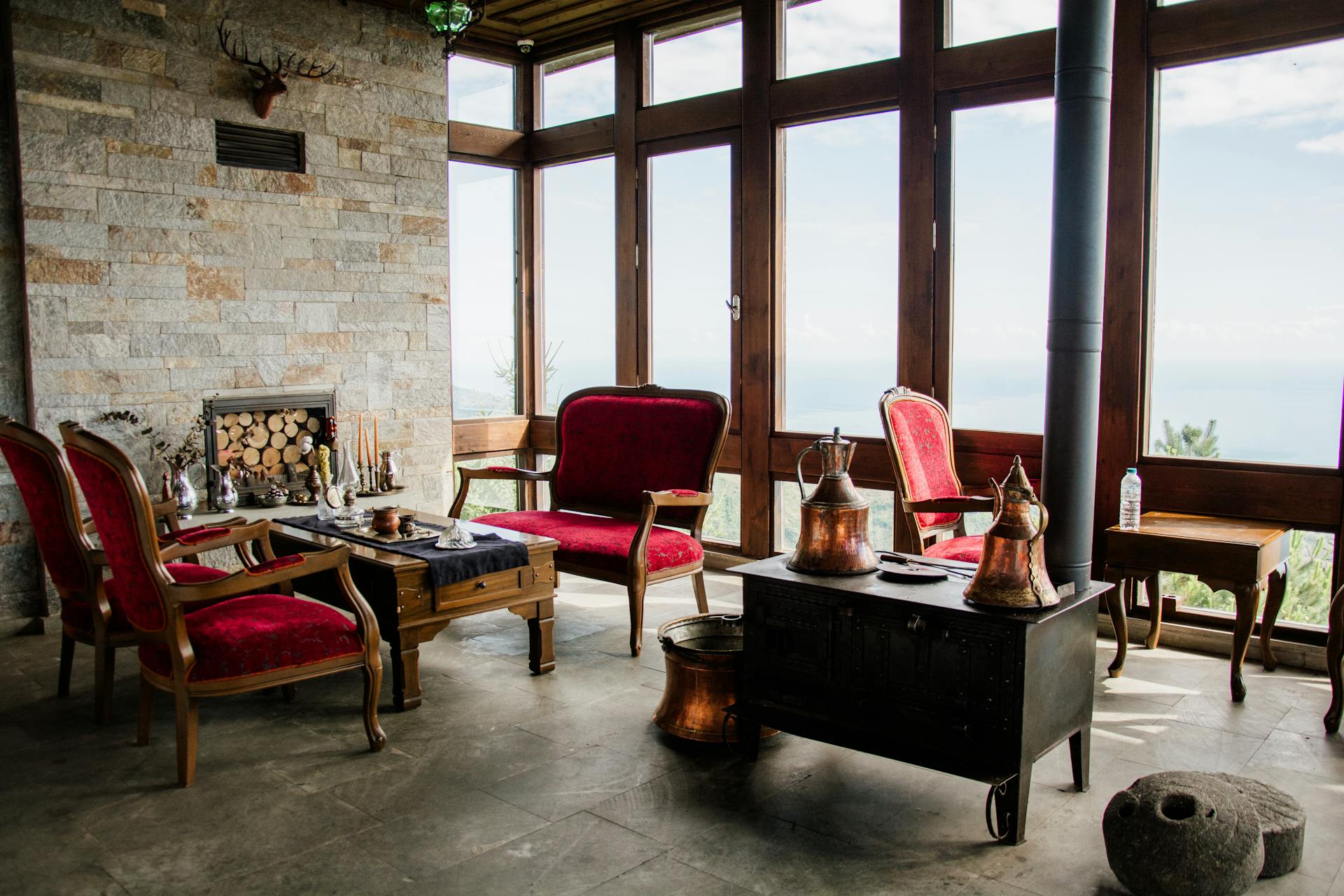 Charming vintage living room with red velvet chairs and scenic window views.