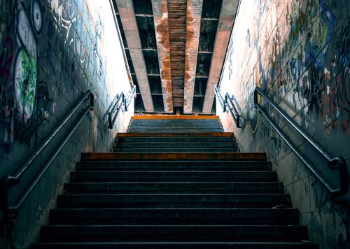 Free A steep subway staircase in Kyiv adorned with graffiti and corroded iron, showcasing urban street art culture. Stock Photo