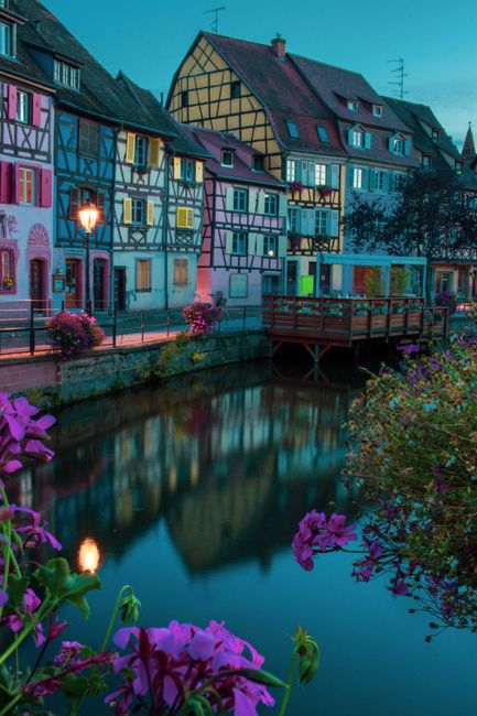 Scenic view of Colmar's colorful houses reflecting in the canal during twilight.