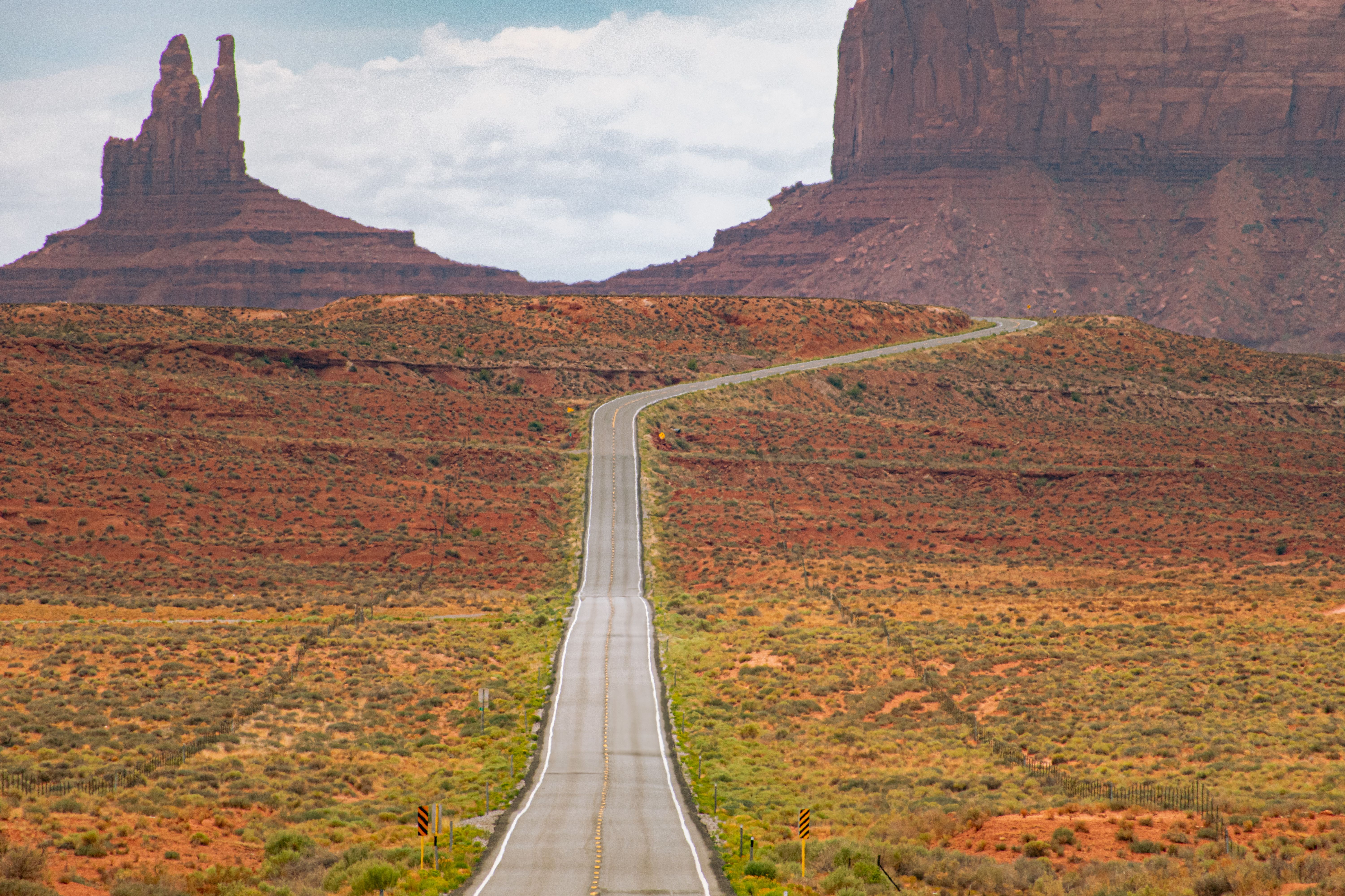 Desert road leading through Monument Valley's iconic rock formations.
