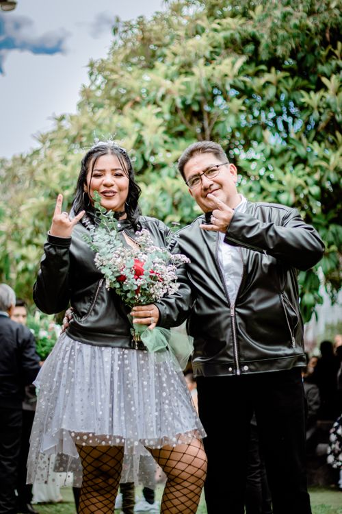 Free A happy couple enjoying a fun moment in an outdoor celebration, surrounded by lush greenery. Stock Photo