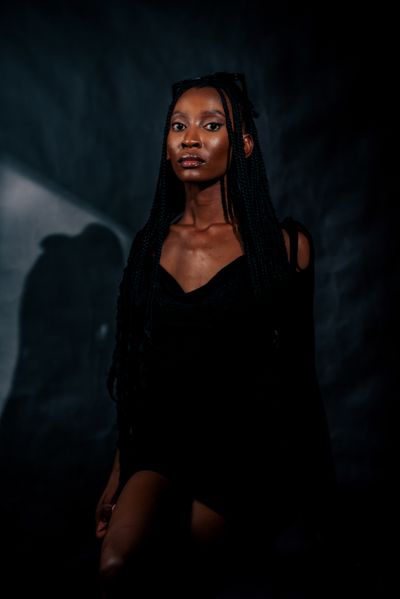 Portrait in dark attire under dramatic light, photo by Lucretius Mooka on Pexels