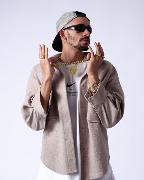 Free A fashionable young man exudes style in a chic urban outfit with gold accessories. Stock Photo