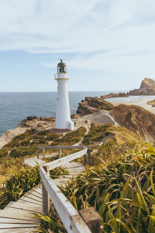 Free Scenic view of Castlepoint lighthouse and rugged coastline in New Zealand. Stock Photo