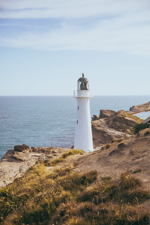 Free A scenic view of Castlepoint Lighthouse on the New Zealand coast during the day. Stock Photo