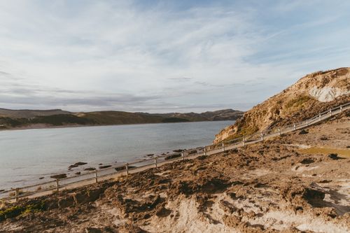 Free Beautiful coastal landscape at Castlepoint, New Zealand, featuring rugged cliffs and serene waters. Stock Photo