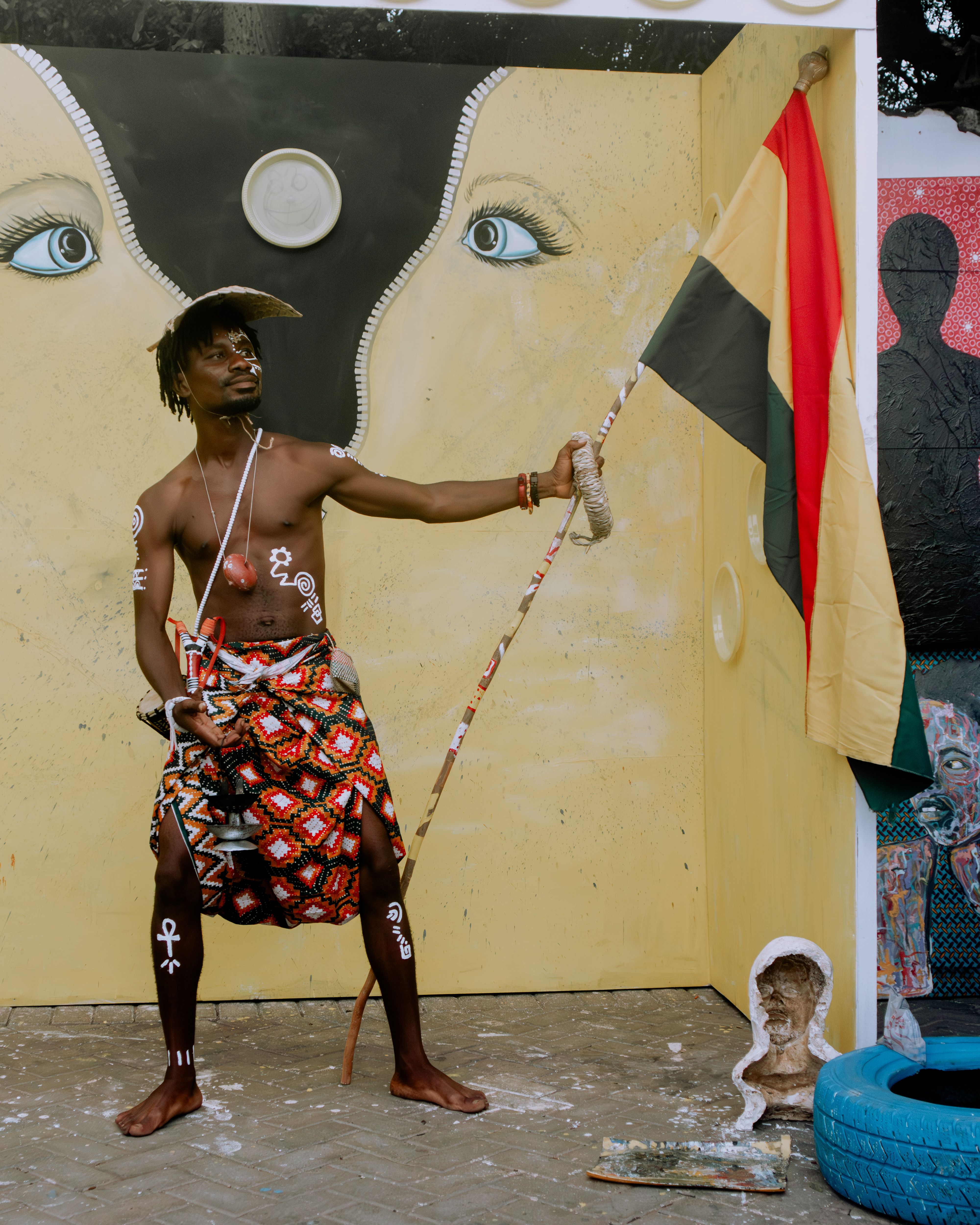 Vibrant depiction of African cultural expression with traditional attire and striking mural backdrop.