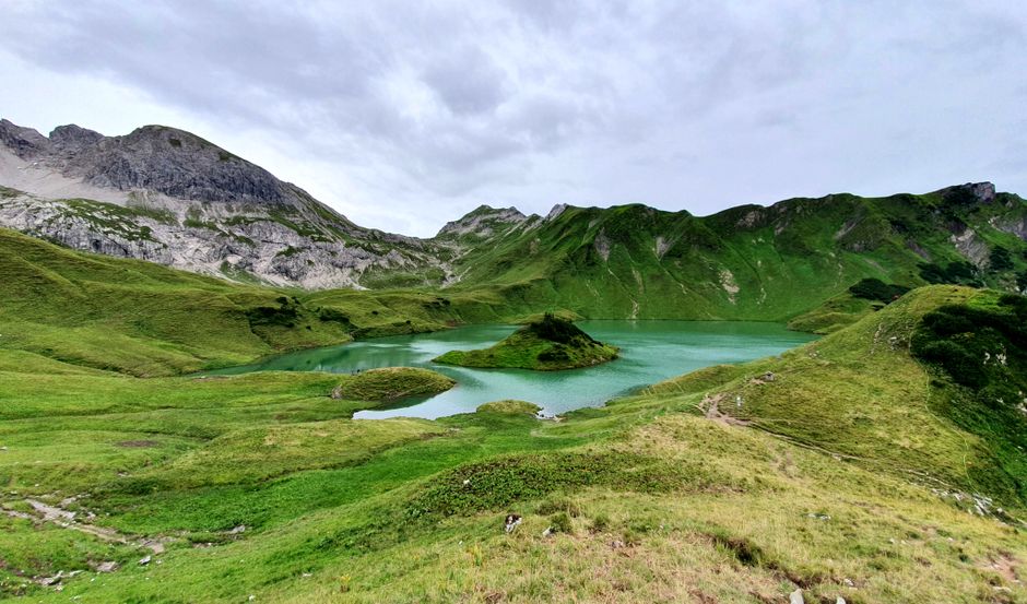 Captivating view of an alpine lake surrounded by lush greenery and mountains in Bad Hindelang, Germany.