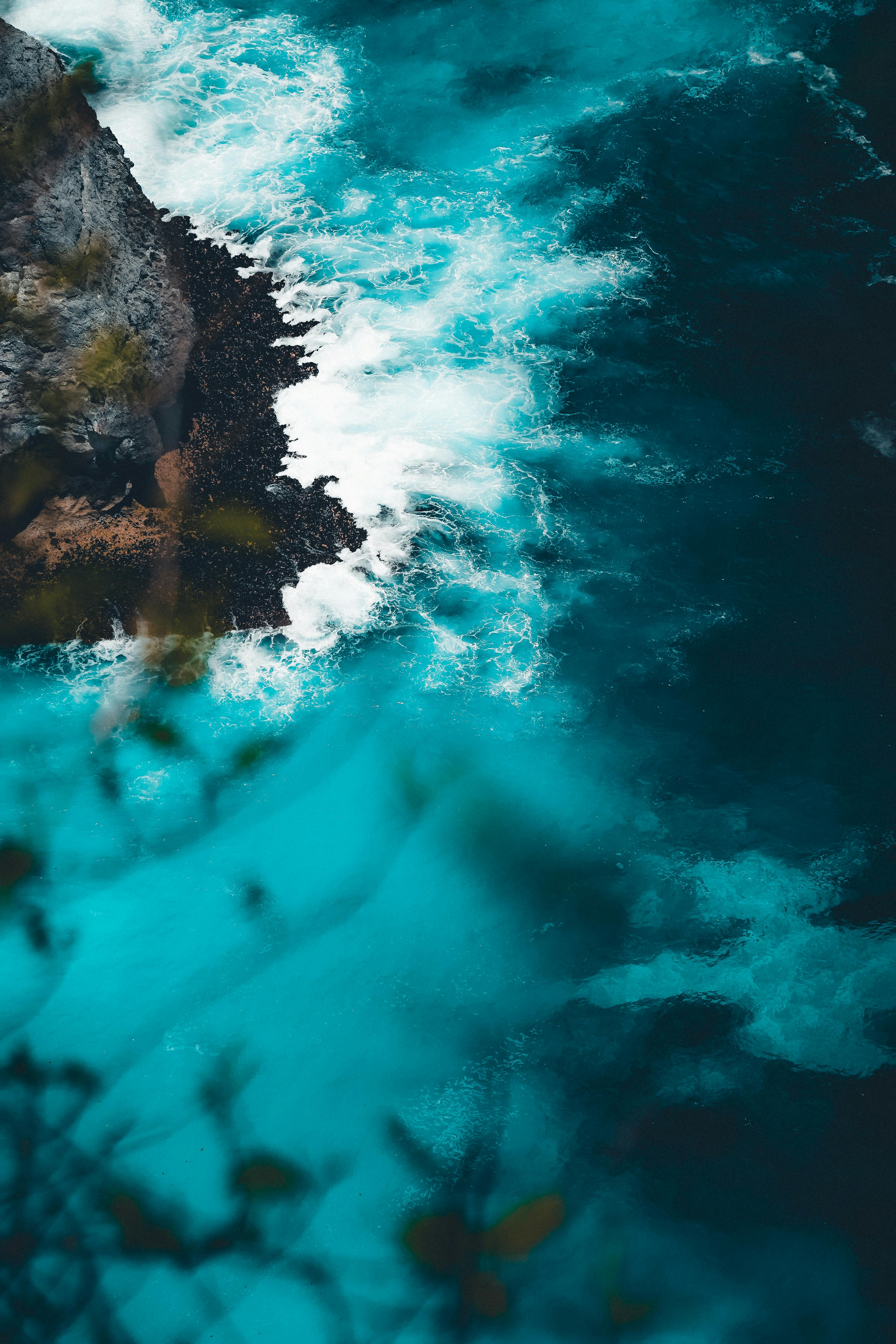 Captivating aerial view of Bali's turquoise blue sea and rocky coastline.