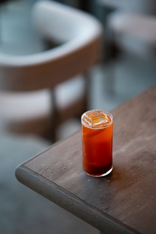Free A refreshing orange cocktail with ice cubes on a rustic wooden table. Stock Photo