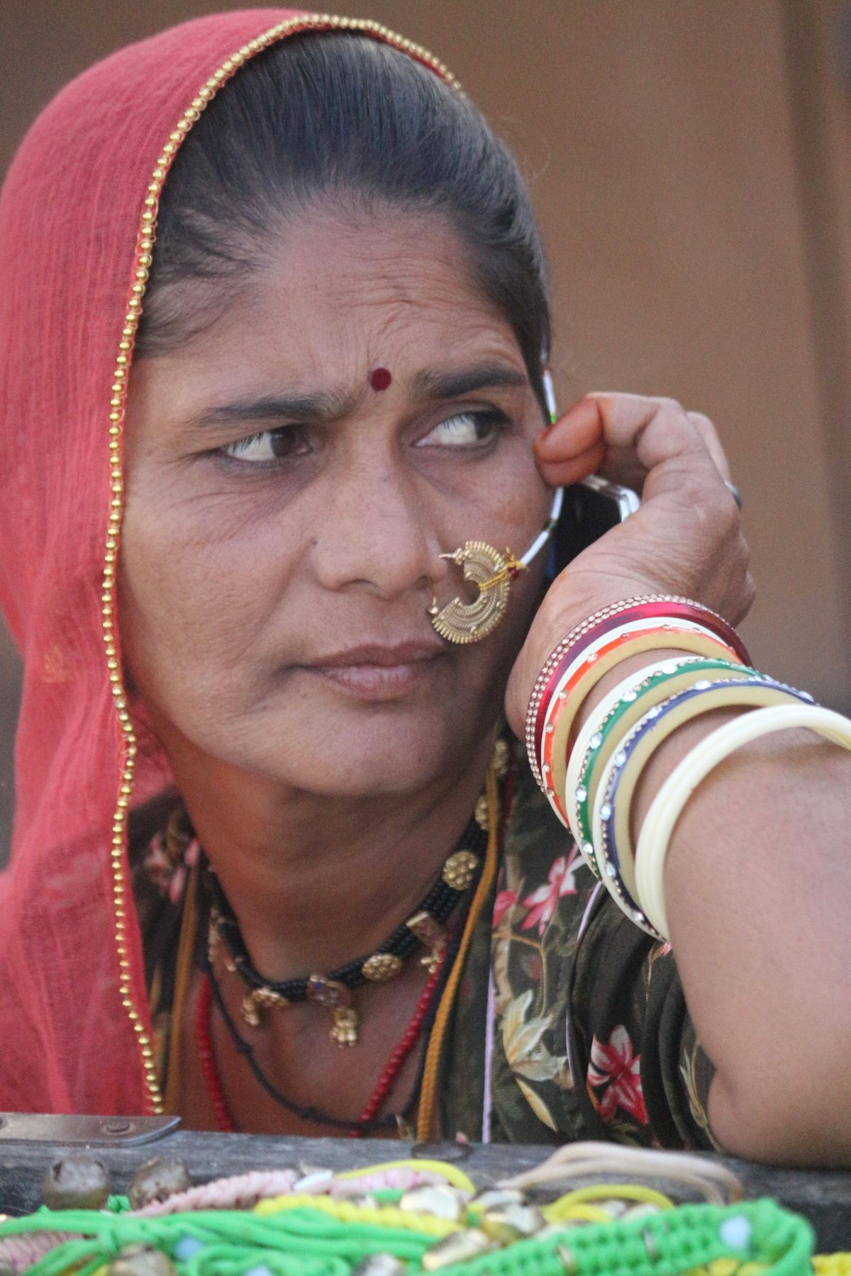 Indian woman borrower in a small town speaking on her phone during a courteous AI EMI reminder call