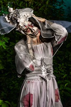 Creative horror-themed costume with intricate skull makeup and veiled headdress outdoors.