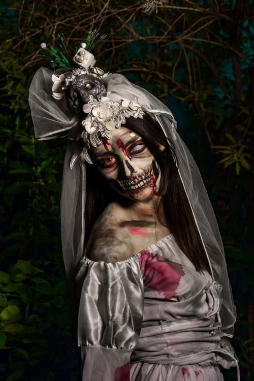 Free Eerie Halloween portrait of a woman in skull makeup and spooky costume outdoors. Stock Photo