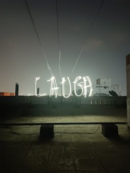 Captivating rooftop light painting showcasing the word "Laugh" against a night sky.
