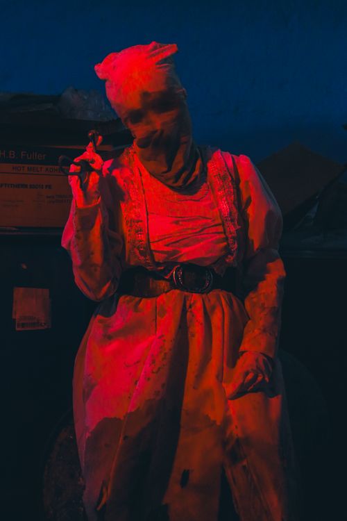 Free A mysterious figure stands in dramatic red lighting at night. Stock Photo