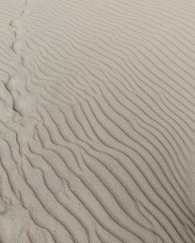 Capture of wavy sand patterns in Nida dunes, Lithuania, showcasing natural beauty.