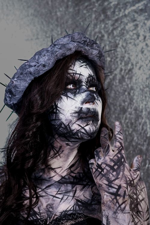 Free A unique artistic portrait featuring a person with creative black makeup and a textured hat. Stock Photo