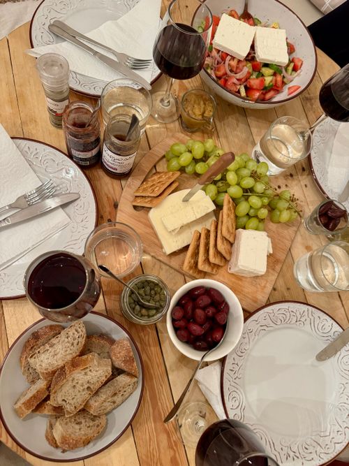 Free Stylish spread of cheese, crackers, and wine on a wooden table setting for a cozy gathering. Stock Photo
