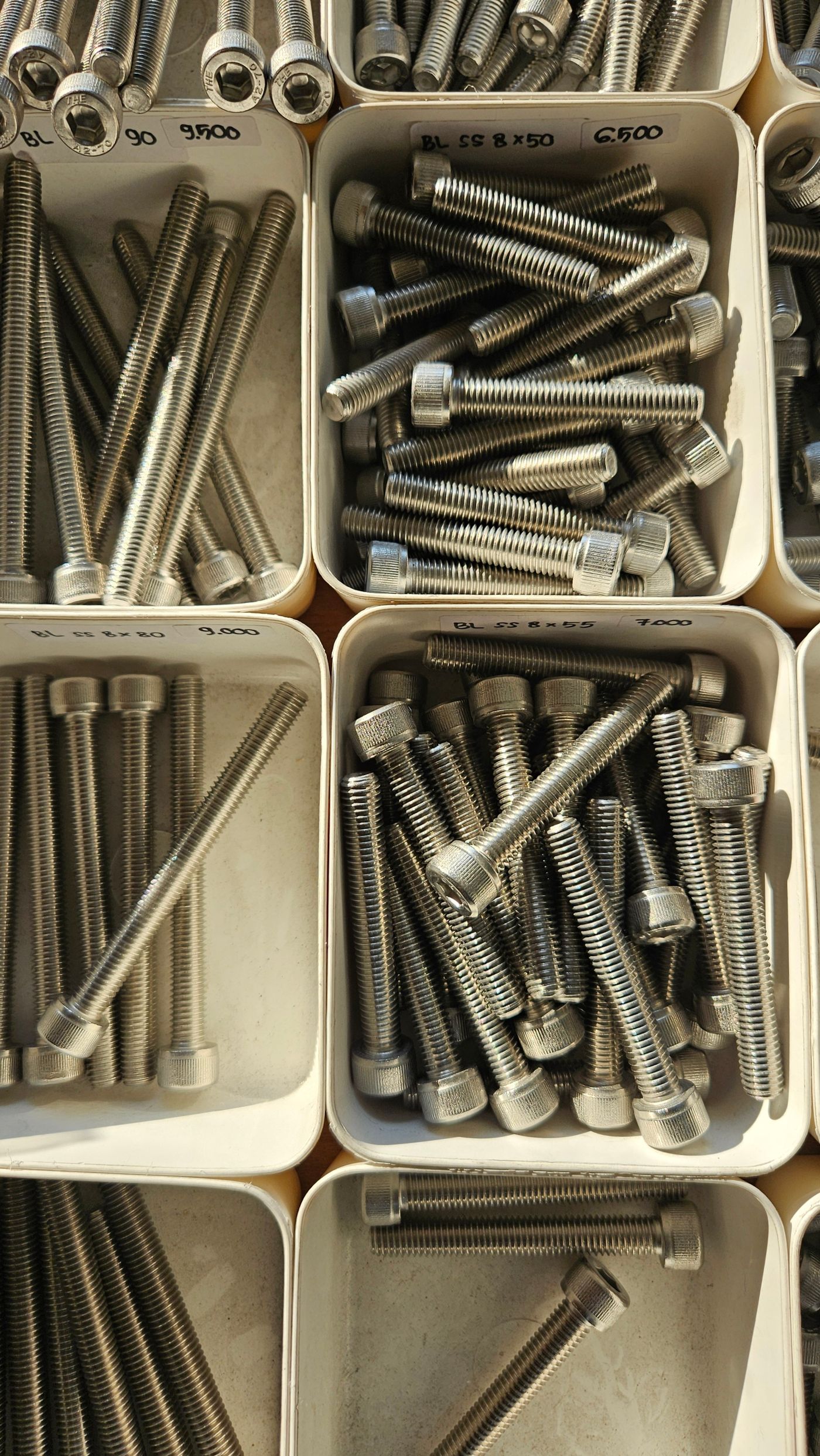 Fasteners organised by size in storage bins