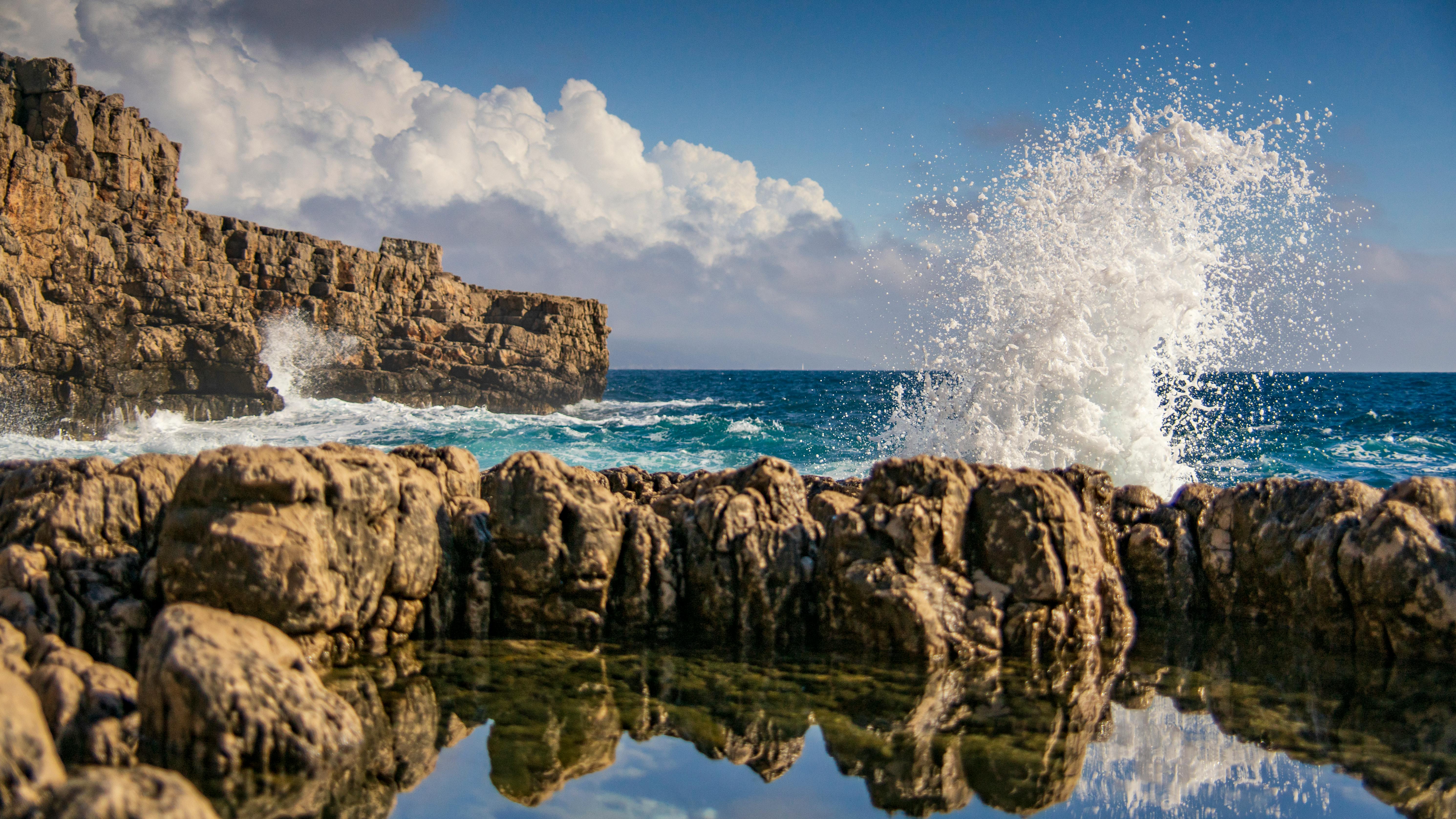 dramatic ocean waves crashing on rocky cliffside