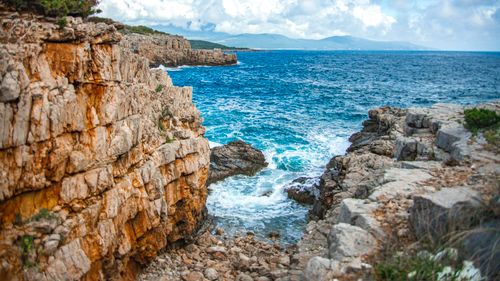 Free Explore the rugged beauty of a rocky coastline with clear blue waters and dramatic cliffs. Stock Photo