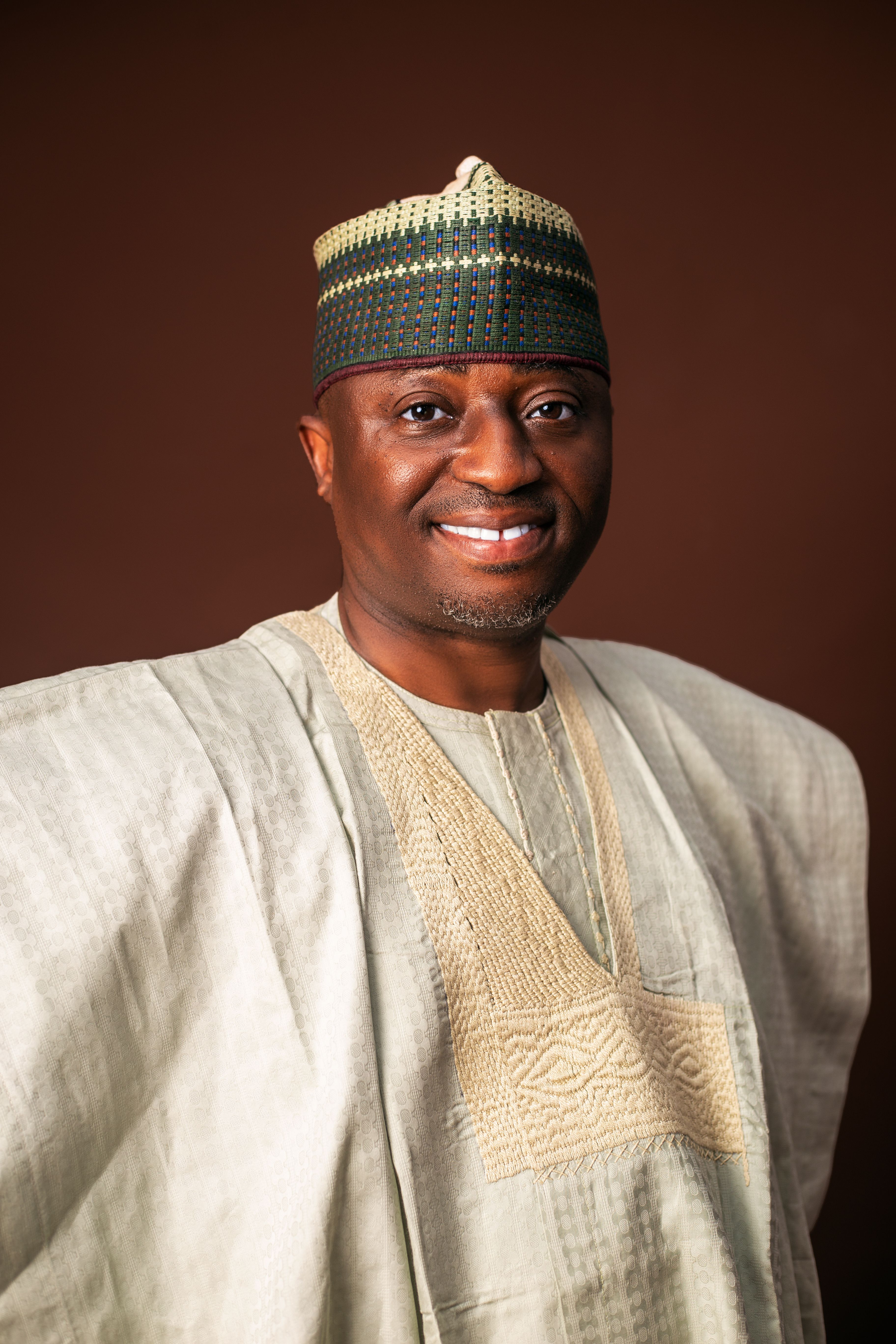 A confident man wearing traditional Nigerian attire in a studio setting. Captures cultural elegance.
