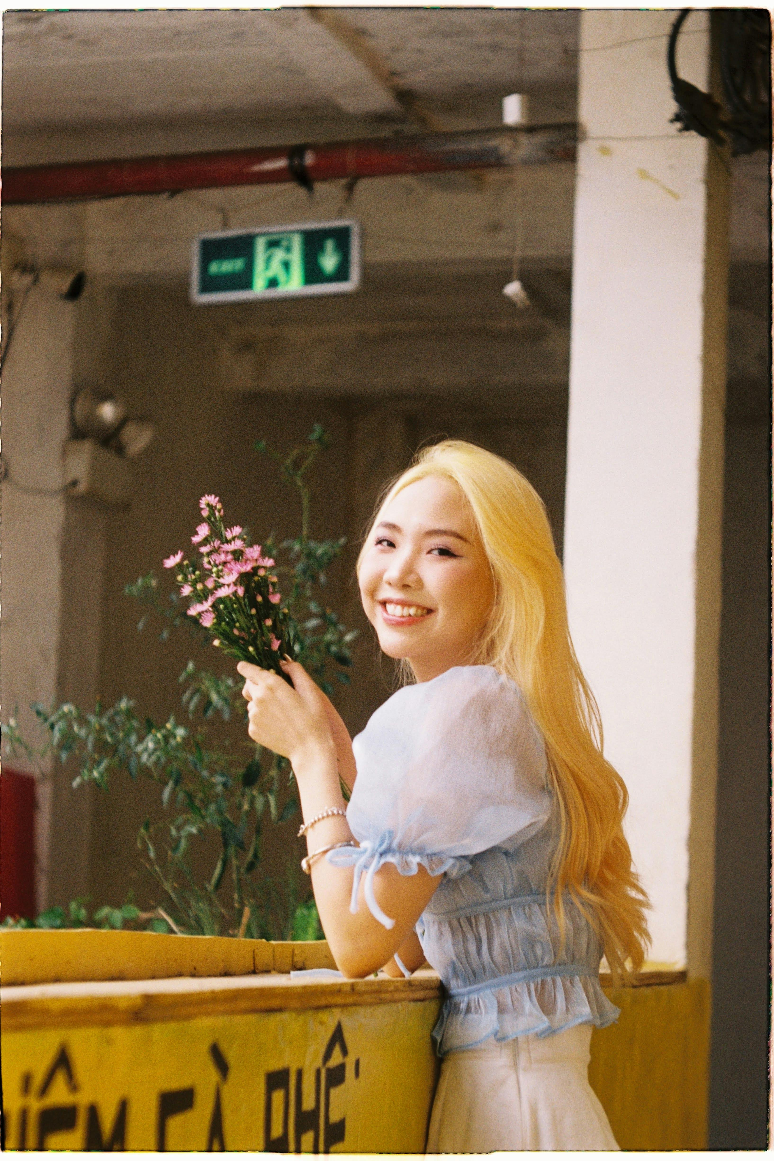 smiling woman with flowers indoors