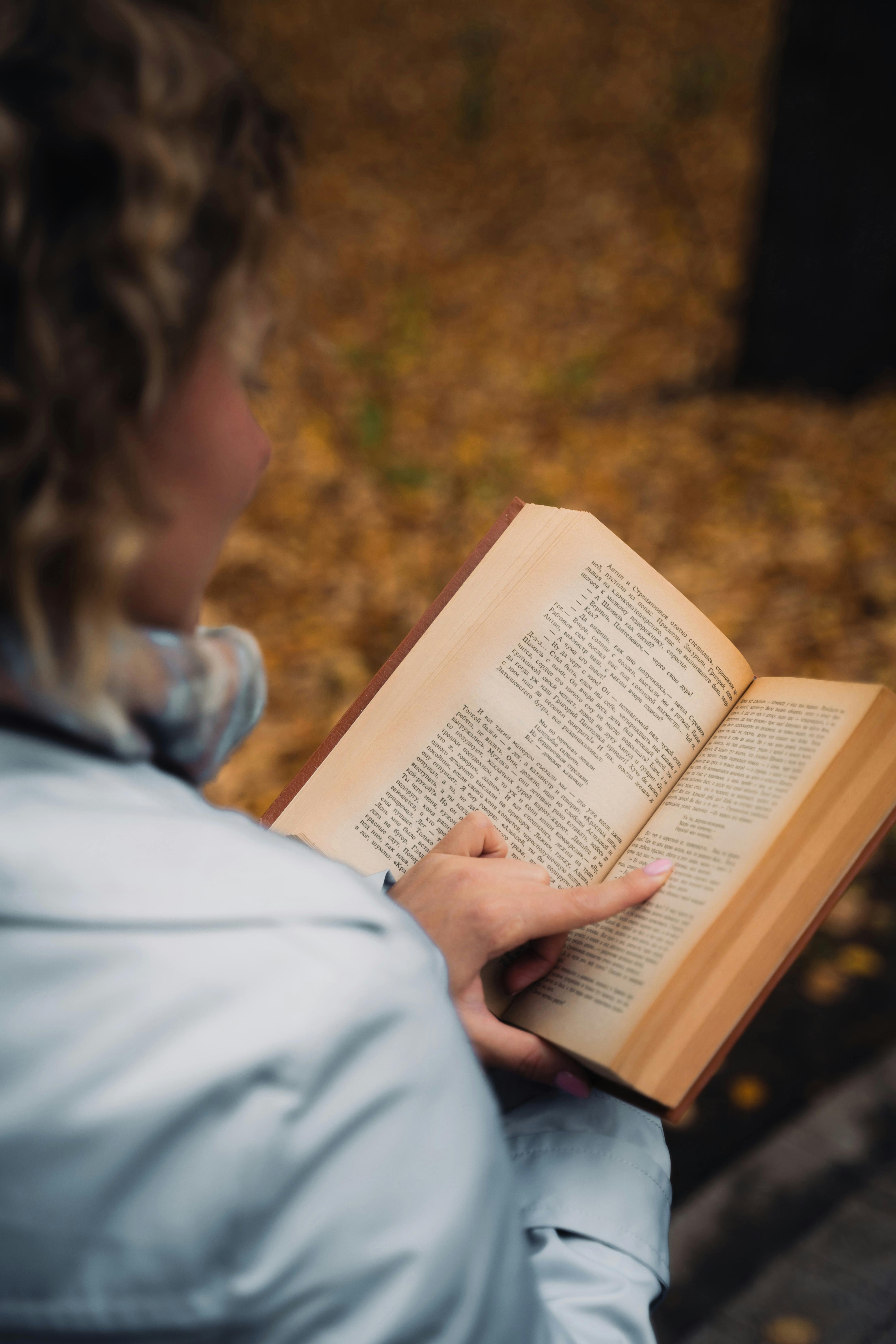 woman reading a book in an autumn park