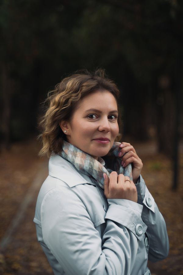 Woman in trench coat with plaid scarf in autumn