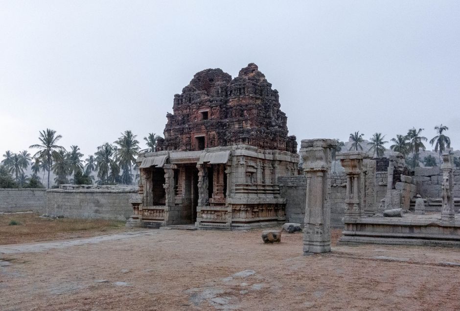 Explore the majestic ruins of an Indian temple surrounded by palms at dawn.