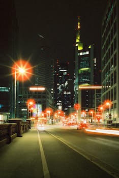 Dazzling night view of a city's illuminated skyline with light trails on the road.