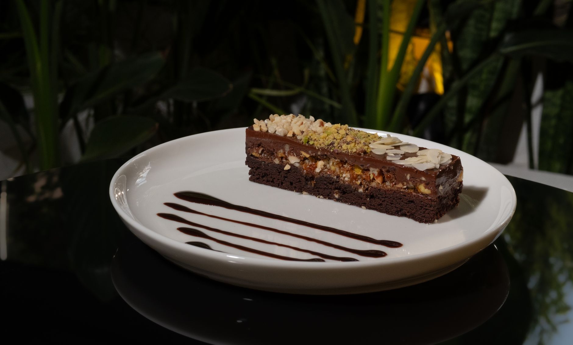 Delicious Chocolate Easter Egg Nests: A Fun Dessert Recipe Chocolate almond cake slice with nuts and sauce garnish on a plate.