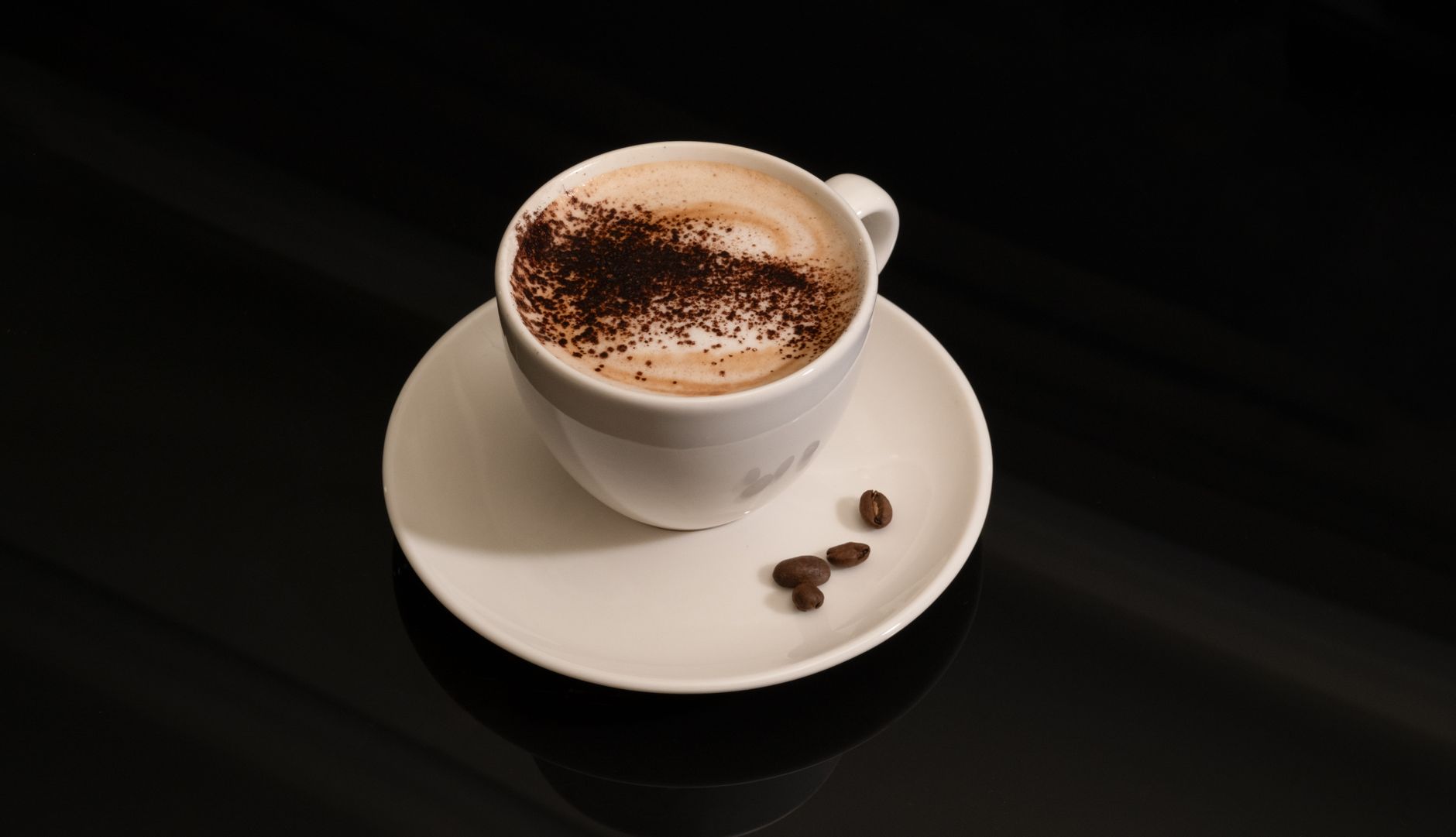 Bote grande de cacao soluble Nesquik junto a una taza de leche con cacao