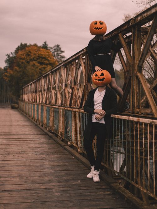 Free Two figures with pumpkin masks on a rustic bridge, perfect Halloween scene. Stock Photo