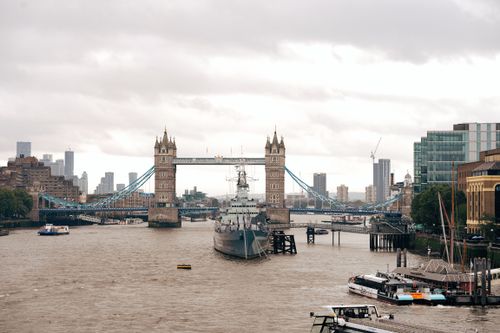Free A scenic view of Tower Bridge and River Thames in London under cloudy skies. Stock Photo