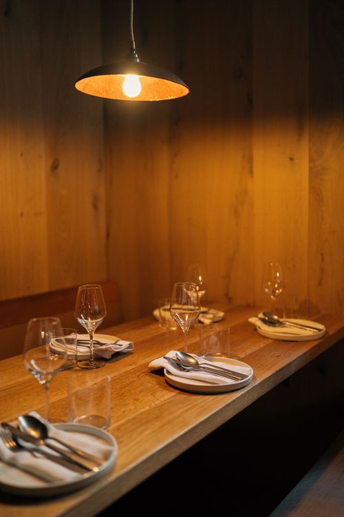 Free Elegant dining setup in a cozy restaurant with warm ambient lighting, ideal for intimate gatherings. Stock Photo